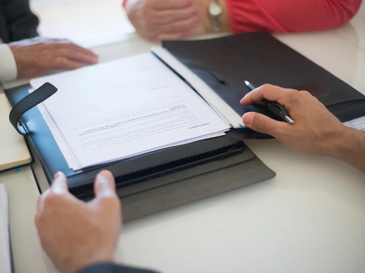 Contract papers and notes spread across a work table
